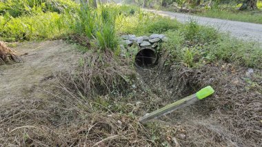 Basit kırsal kanal sulama ve drenaj sistemi. Palmiye yağı tarlalarında taş yığını var..
