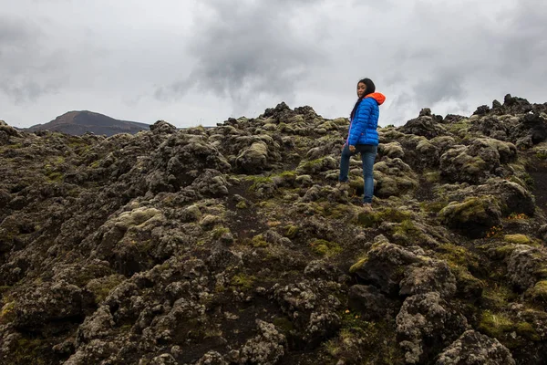 Una donna si erge su un campo di lava ricoperto di muschio — Foto Stock