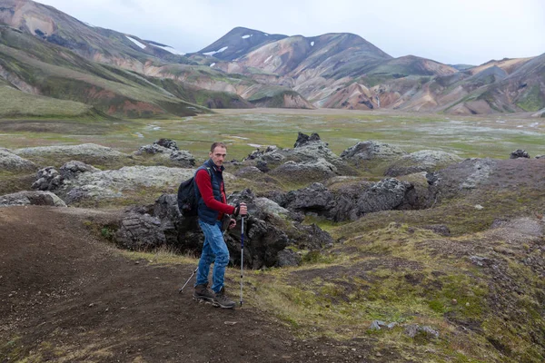 Um homem com postes de trekking viaja pelas montanhas — Fotografia de Stock