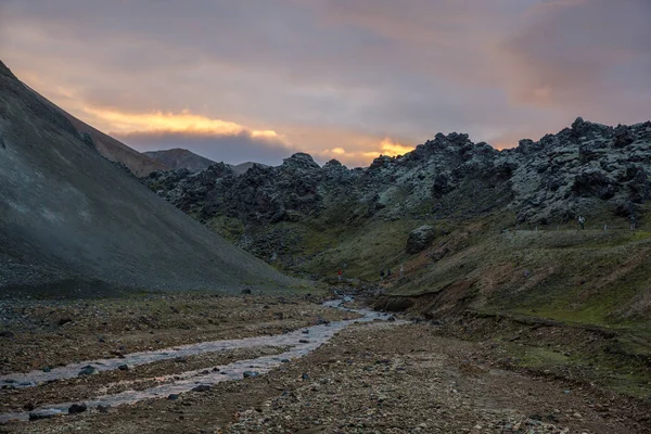 Gebirgsfluss fließt bei Sonnenuntergang zwischen den Felsen — Stockfoto