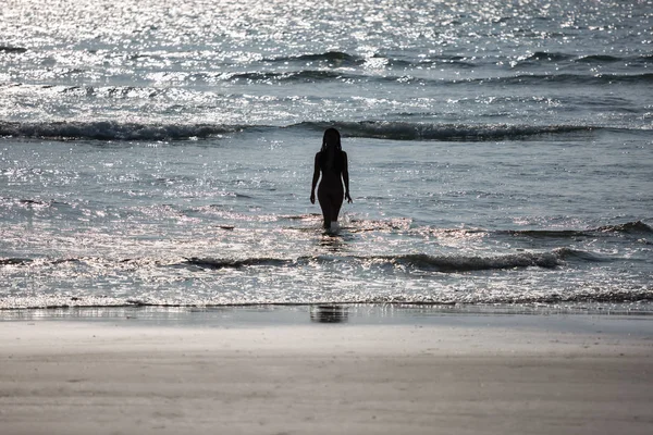 Silhueta de uma menina nua saindo do mar — Fotografia de Stock