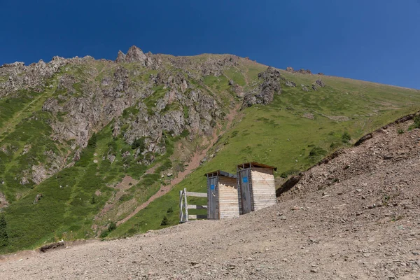 Два дерев'яні туалети стоять на вершині гори — стокове фото