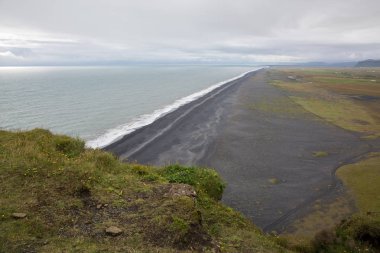 Siyah lav kumu ile deniz kıyısında yüksek uçurum