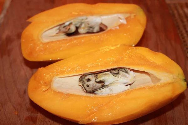 In Scheiben geschnittene Mango mit Knochen auf hölzernem Schneidebrett — Stockfoto