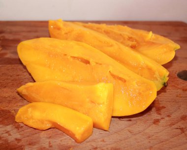 Mango bir ahşap mutfak kesme tahtası üzerinde dilimlenmiş