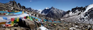 Dolma La geçmek Tibet'te Kailash Dağı alanında ön plan ritüel bayrakları ve taş placers.