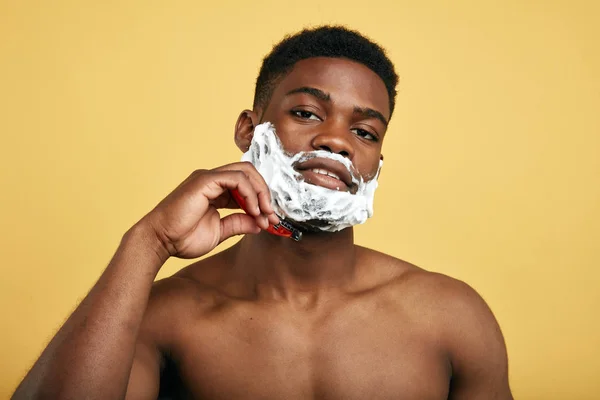 pleasant man using disposable razor