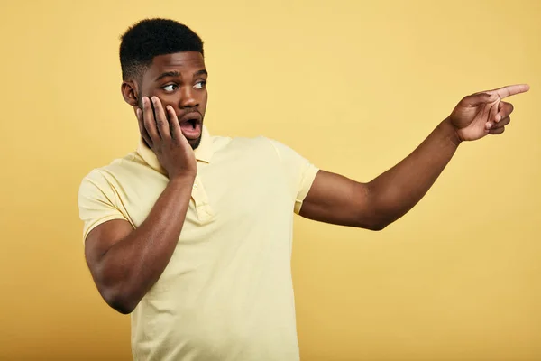 Erstaunt emotionaler junger dunkelhäutiger Mann in stylischem T-Shirt — Stockfoto