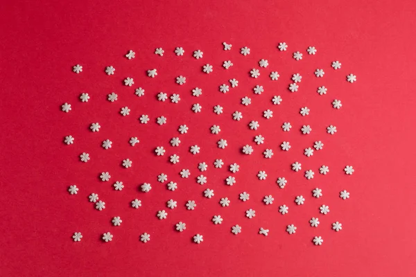 Composition from small snowflakes on the red table — Stock Photo, Image