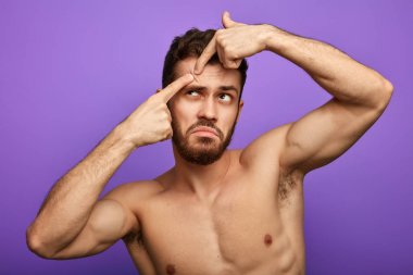 Genç çıplak adam cildine özen gösterir.