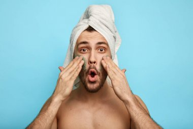 rahat sakallı adam yanağına bir maske uygulayarak