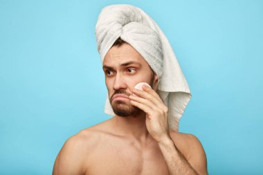 üzgün mutsuz memnun adam yanağını silerek ve kenara bakarak