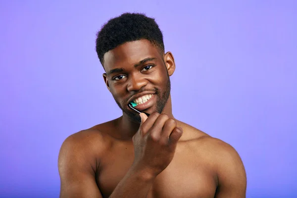 Lächelnder junger Mann mit Zahnbürste im Mund — Stockfoto