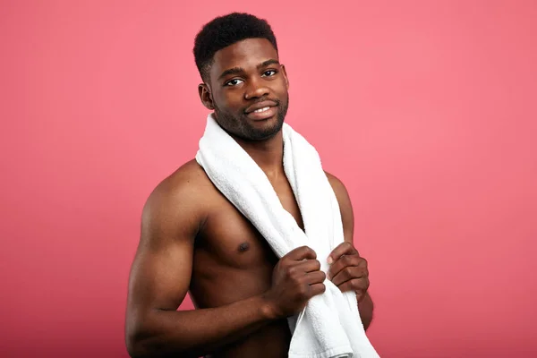Attraktive junge fröhliche Mann mit einem Handtuch um den Hals entspannen nach der Dusche. — Stockfoto