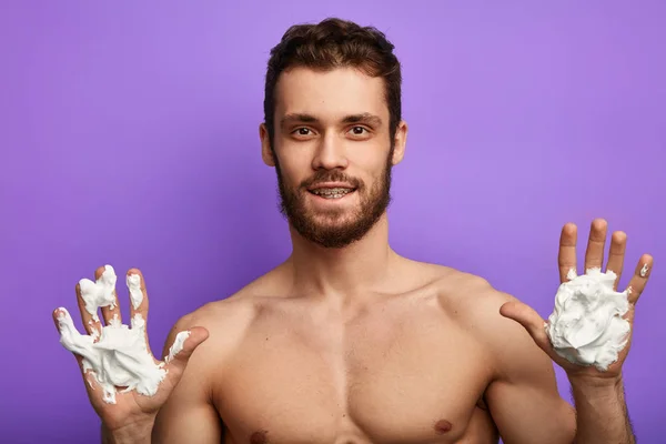 Beauté masculine. bel homme montrant les mains avec mousse à raser — Photo