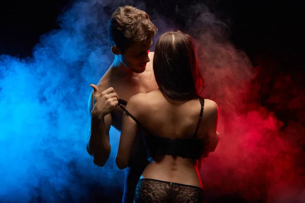 Man helps his woman to take off black lace lingerie — Stock Photo, Image