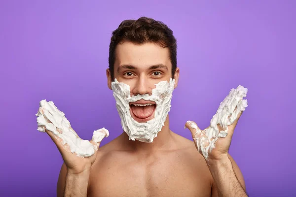 Αστείος νέος άντρας με πρόσωπο καλυμμένο αφρό ξυρίσματος — Φωτογραφία Αρχείου