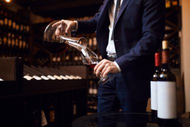 Genç adam şarapları karıştırıyor. Unutulmaz şarabın yaratılışı