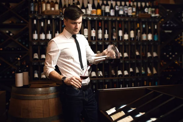 Atractivo joven en traje blanco y pantalones degustación de vino tinto — Foto de Stock