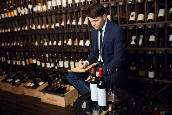 Hombre en traje de moda ellegant anotar información sobre el producto del vino — Foto de Stock