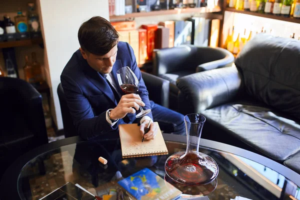 young clever man writing articles about fine wines