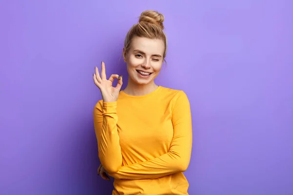 Emocjonalna urocza kobieta pokazując OK znak z palcami i mrugając — Zdjęcie stockowe