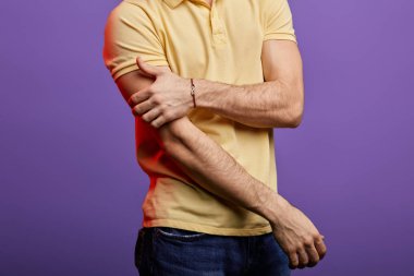 kırpılmış fotoğraf kadar yakın. sarı t-shirt ve kot adam kolunu germe, cricking