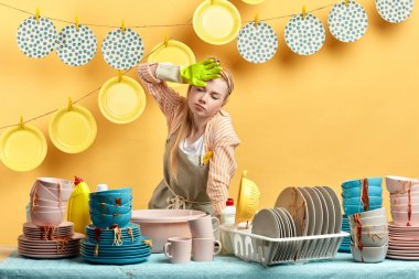 Yorgun yorgun temizleyici mutfakta ayakta ve alnına el tutun.