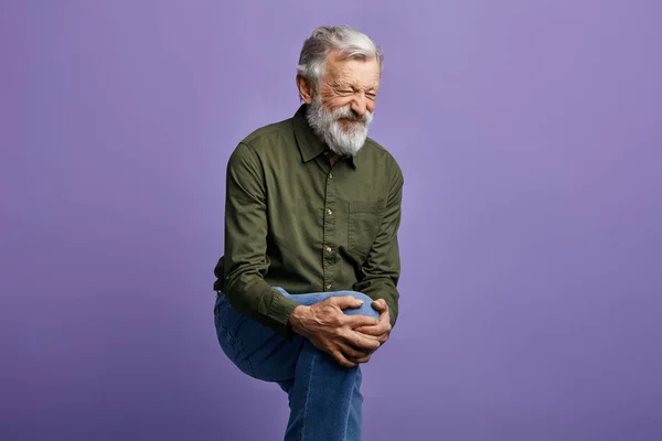 Mavi arka plan izole diz ağrısı muzdarip yaşlı adam — Stok fotoğraf