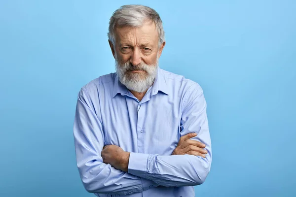 Şüpheci ifade ile mavi gömlek yakışıklı yaşlı adam — Stok fotoğraf