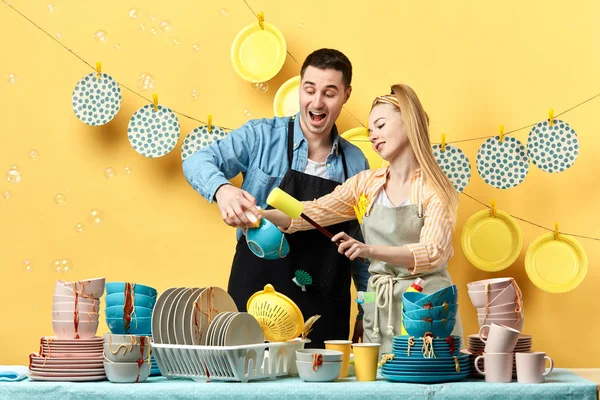 Animado casal alegre lavar pratos, intestinos, copos à mão — Fotografia de Stock