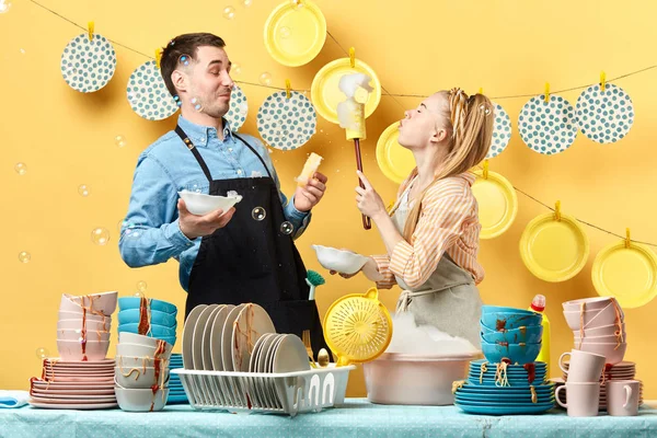 Funny young blonde woman with closed eyes blowing foam to her boyfriend — Stock Photo, Image