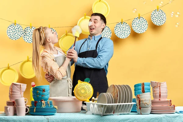 Funny housewife trying to wash her husband in the kitchen — Stock Photo, Image