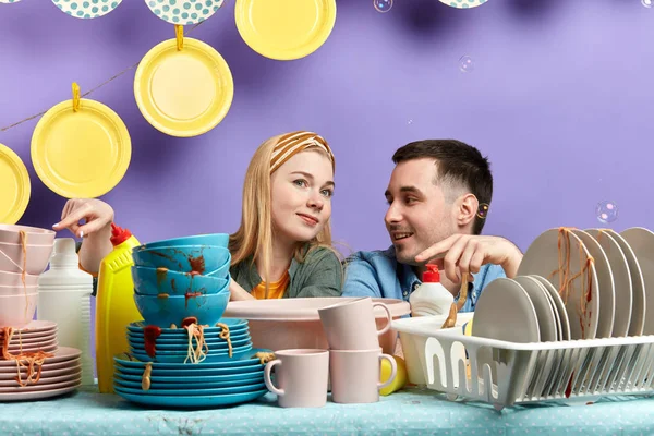 young couple poiting at unwashed tablewear
