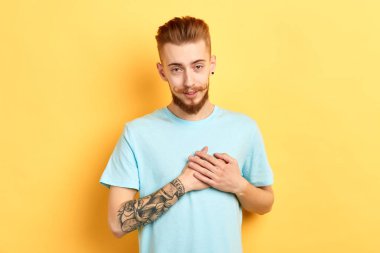 kolunda dövme ile hoş genç şık adam kameraya bakarak