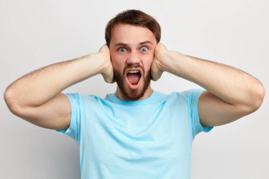 kulaklarında avuç içi ile sinirli kızgın adam