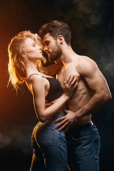 Jonge man met een onbevlogen blik, hete lever knuffelen een vrouw in zijn armen — Stockfoto
