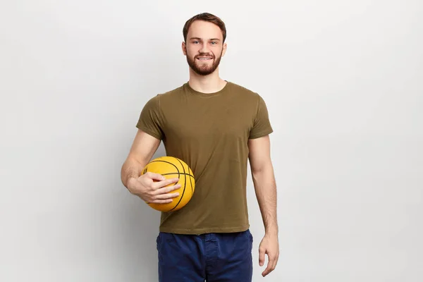 Guapo en forma hombre en ropa casual jugando con una pelota —  Fotos de Stock