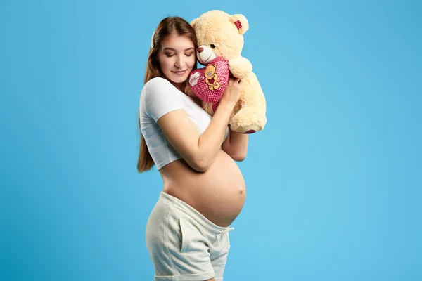 Mulher feliz com olhos fechados gostando de brincar com seu bebê no útero — Fotografia de Stock