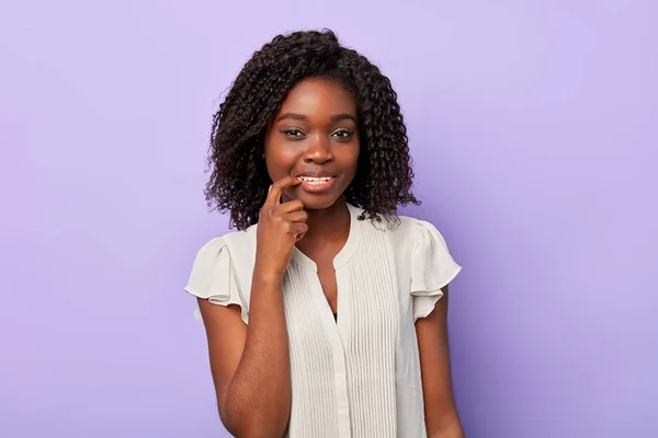 Porträtt av en ung lycklig afro kvinna som pekar på hennes tänder — Stockfoto