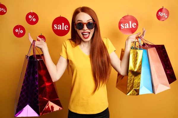 Mujer de compras emocionada en gafas de sol expresa alegría —  Fotos de Stock