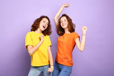 şık neşeli güzel iki kız kardeş mavi duvar ile stüdyoda eğlenmek