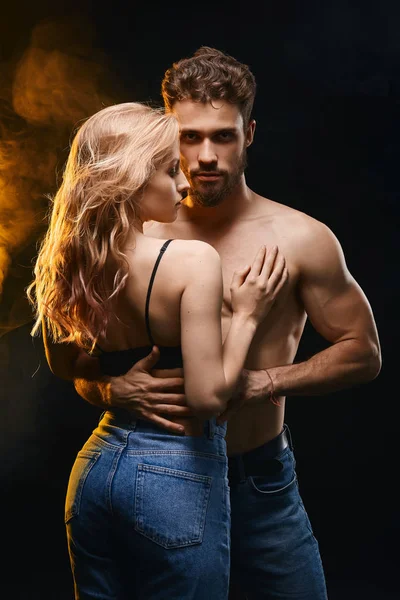 kız arkadaşını kucaklarken kameraya bakarak genç yakışıklı adam