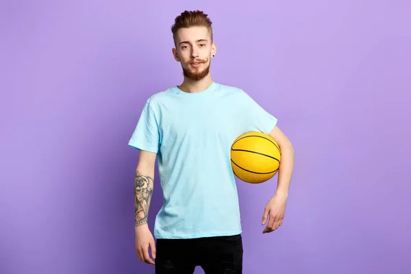 Um jovem barbudo segurando um basquete isolado no fundo azul — Fotografia de Stock