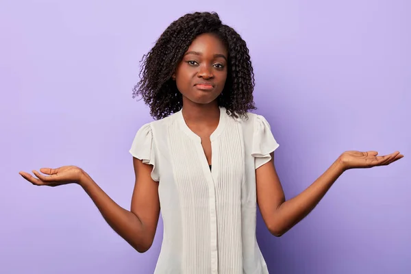 doubtful shocked African woman shrugging shoulders