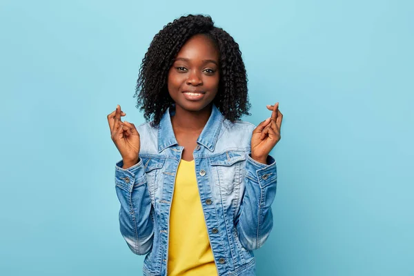 Alegre sorrindo mulher americana com dedos cruzados posando para a câmera — Fotografia de Stock