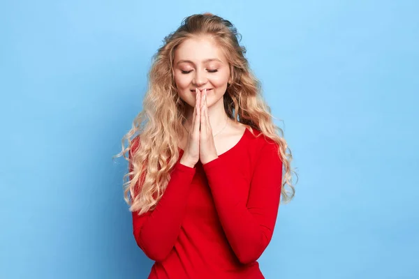 Cute happy cheerful girl with closed eyes keeps hands in praying gesture — Stock Photo, Image