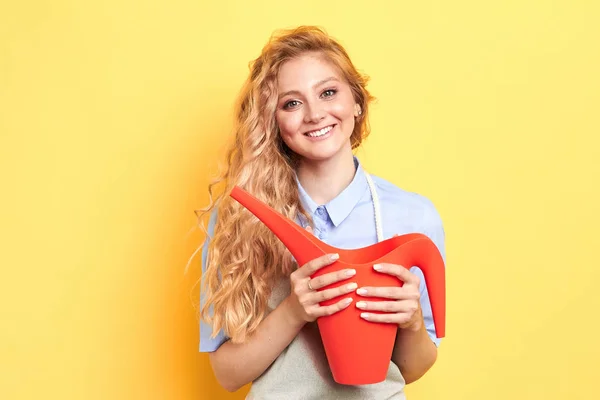 Fiatal pozitív mosolygó nő, aki vörös öntözés — Stock Fotó