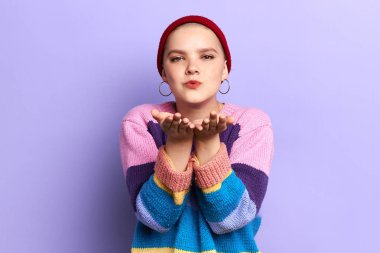 kırmızı şapkalı genç hipster kız ve çizgili kazak hava öpücük darbeler
