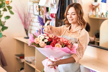 genç çekici sevimli çiçekçi dekorasyon buketi zevk alır